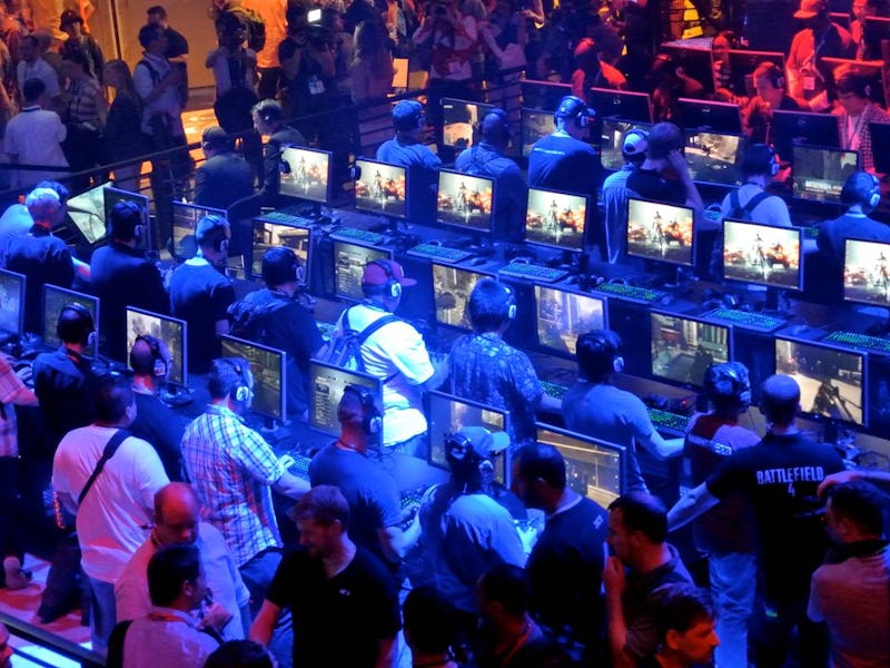 Visitors play computer games ar the fair stands of exhibitors at the E3 games fair in Los Angeles; U...