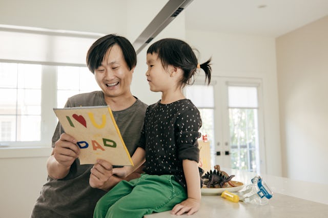 Daughter and father celebrating Fathers day together with a homemade Father's Day craft.