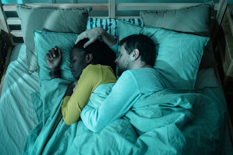 Couple cuddling together in the bed sleeping at night