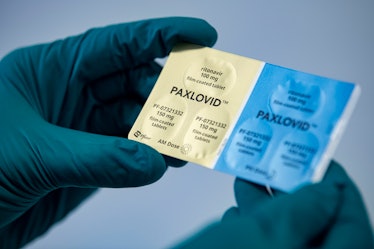 01 March 2022, Berlin: A person holds the drug Paxlovid from the US pharmaceutical company Pfizer ag...