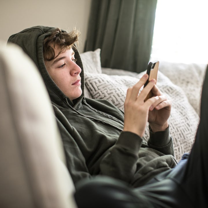 Teenage boy using smartphone at home. A new study from Trinity College in Dublin has a new "Goldiloc...