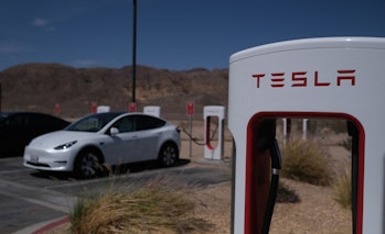 Tesla cars sit at charging stations in Yermo, California, on May 14, 2022. (Photo by Chris Delmas / ...