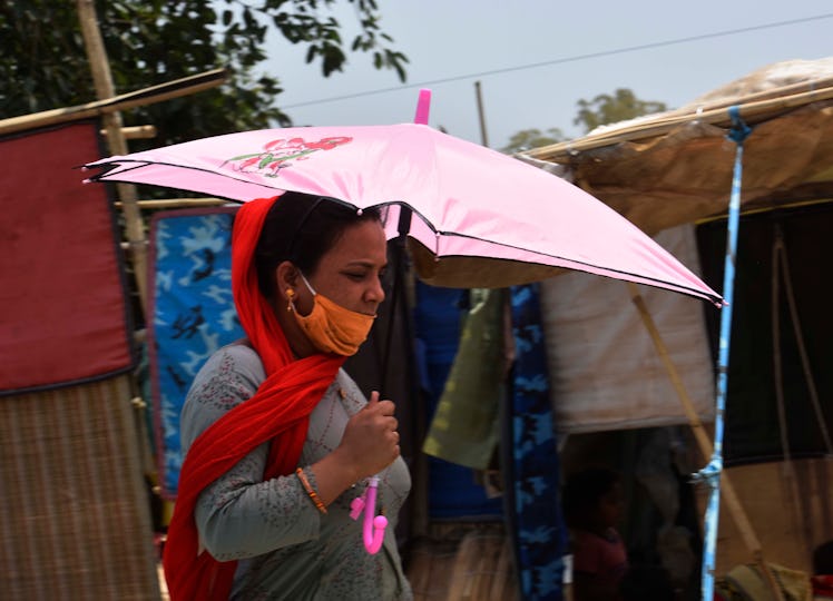 GURUGRAM, INDIA  APRIL 28: A woman walks under the shade of her umbrella in the midst of an ongoing ...