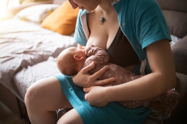 Mother holding and breastfeeding newborn baby boy.