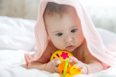 A baby focused on a toy.
