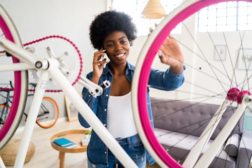 A woman fixes a hot pink bike. Here's your july 12 zodiac sign daily horoscope.