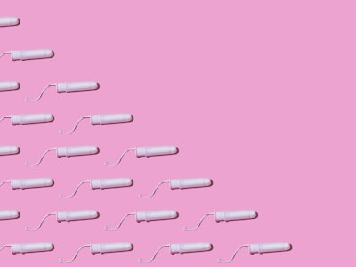 Cellulose white tampon pattern with twine, on the left side, on pink background. Concept of menstrua...