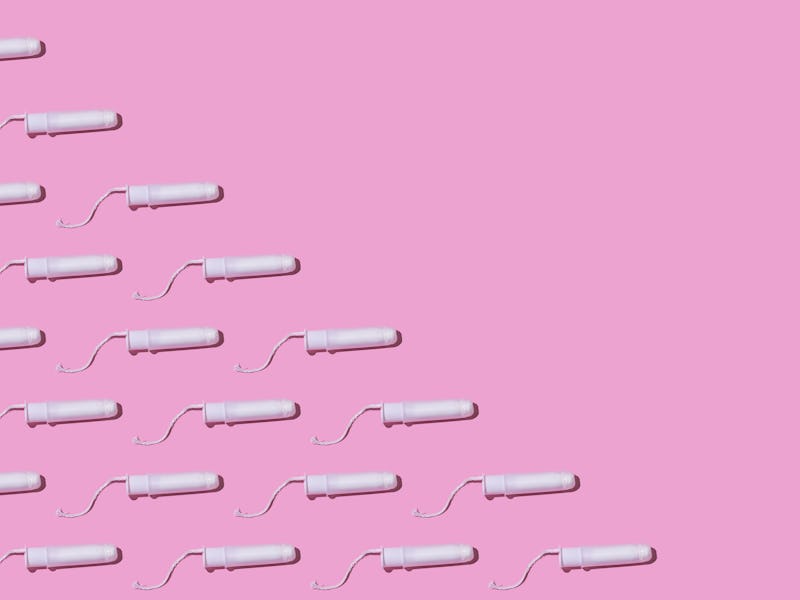 Cellulose white tampon pattern with twine, on the left side, on pink background. Concept of menstrua...