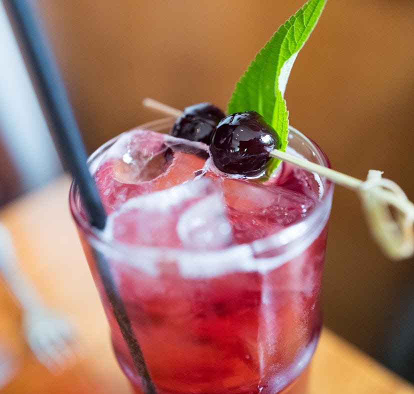 Close-up of the top of a pomegranate flavored Shirley Temple drink with artisan maraschino cherries,...