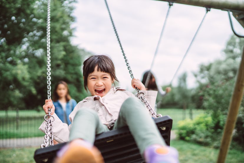 Lovely little girl smiling and playing outside in long pants in an article about why some kids get m...