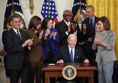 US President Joe Biden (C) prepares to sign an executive order intended to strengthen the Affordable...