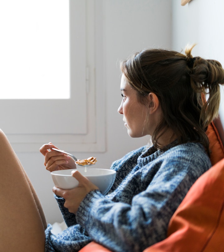 woman eating in bed, what to eat after a miscarriage to help your body heal