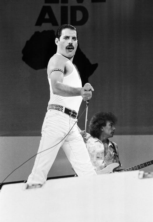 Freddie Mercury, lead singer of British rock group Queen, performing on stage at Wembley Stadium dur...