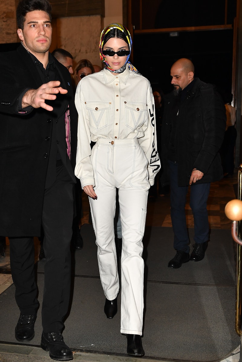 Kendall Jenner wears high-waisted white jeans and a matching white denim jacket