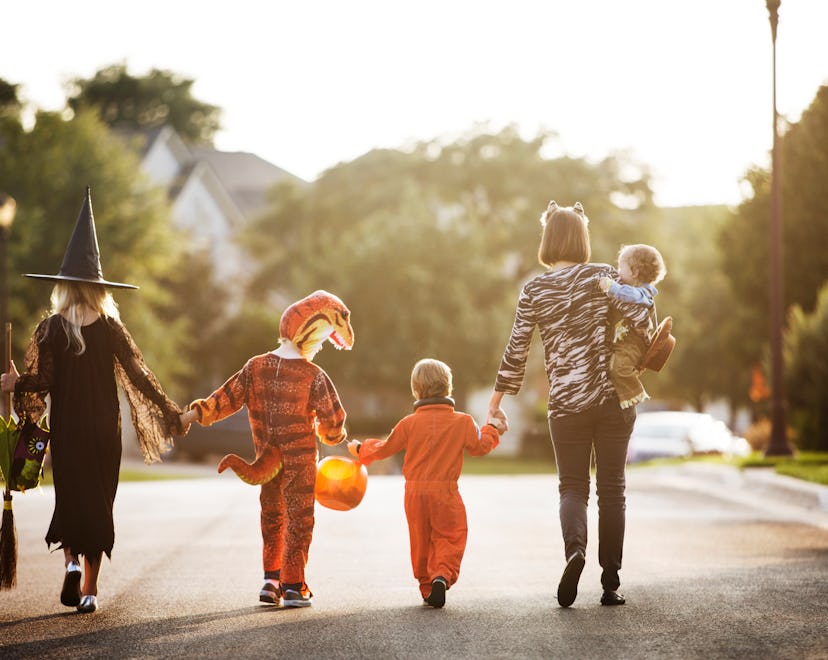 a family in costums out trick or treating in an article about when Home Depot will put out Halloween...