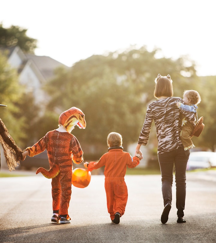 a family in costums out trick or treating in an article about when Home Depot will put out Halloween...