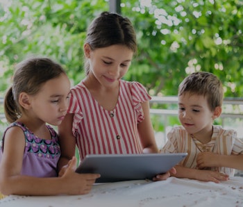 Happy Children Using Digital Tablet Outdoors