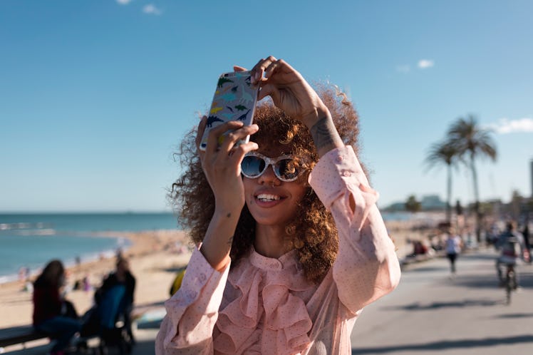A woman uses fun Instagram Reel ideas for capturing her summer memories.