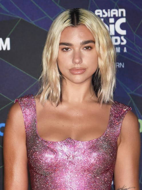 Dua Lipa showcasing the peekaboo color on blonde hair — a highlight trend reminiscent of the early a...