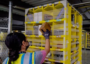 EASTVALE, CA - AUGUST 31: Worker Melissa Navarrete Urena stows goods into a movable pallet at Amazon...