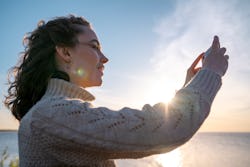 A woman takes a photo in the sun. These are the most common traits of a cancer-leo cusp sign.