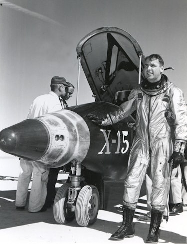 Portrait of American military test pilot Major Robert M. White (1924 - 2010) as he poses with his ha...