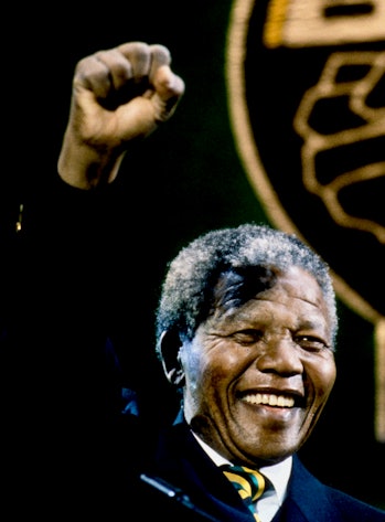 View of South African politician Nelson Mandela (1918 - 2013) as he raises a fist from the stage dur...