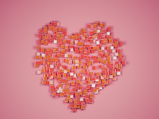 Abstract heart shape form by group of red and orange cubes on red background still life