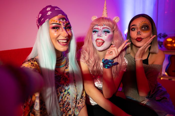 Girls taking selfies at Halloween party, cool halloween costumes for teens