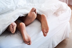 Shot of a couple’s feet poking out from under the sheets in an article about whether or not missiona...