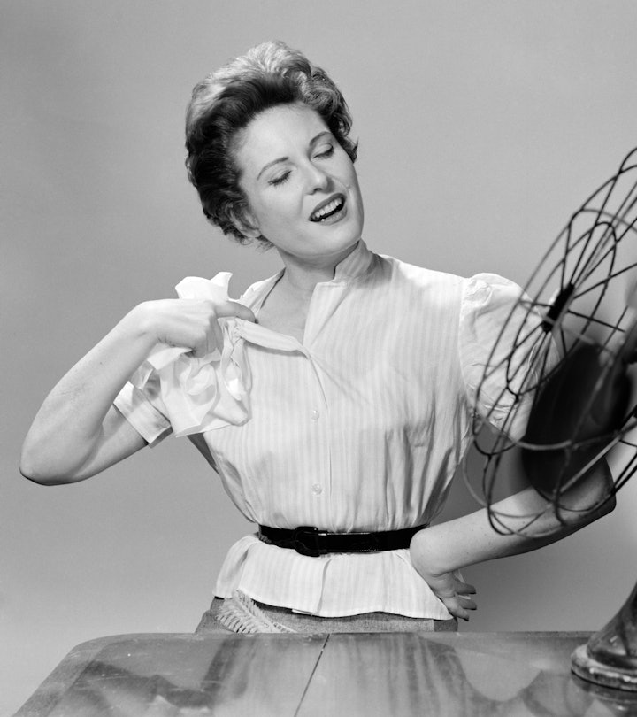 1950s WOMAN COOLING WITH SWIVEL FAN  (Photo by Debrocke/ClassicStock/Getty Images)