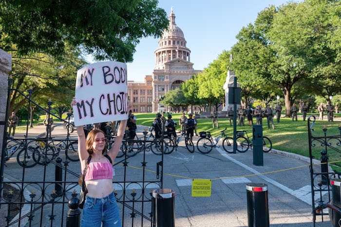 Law enforcement officers keep the protesters outside of the Austin State Capitol gates.