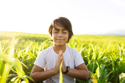 boy practicing yoga in field, mindfulness activities for kids