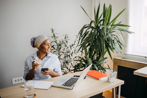 Woman with a phone is sitting in her home office using snapchat for web browser. How to use snapchat...