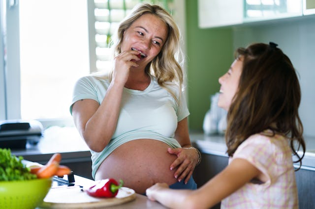 Happy girl preparing lunch whit her pregnant mother at home