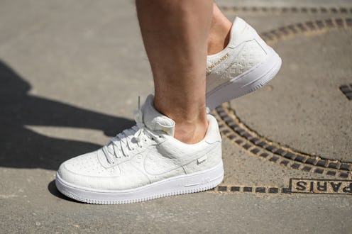 PARIS, FRANCE - JUNE 23: A guest wears white embossed LV monogram print pattern Air Force One sneake...