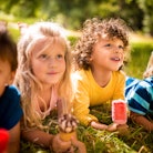 Sweet mixed racial group of happy friendly children eating ice creams in a park together