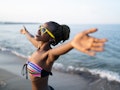 African woman having fun at beach, hands outstratched