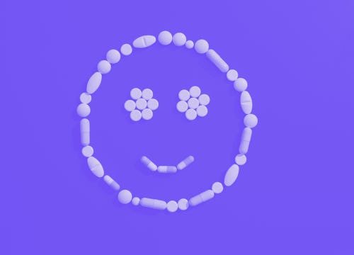 Medical pills placed in the shape of a smiley face