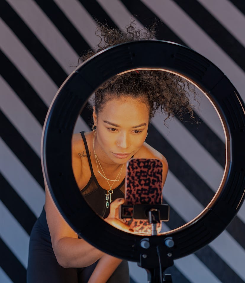 Afro Latin woman of average age of 30 years with dark skin dressed in sportswear influencer is in fr...