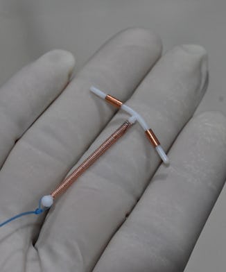 This picture taken on June 25, 2020 shows a doctor holding an IUD birth control device to put into a...