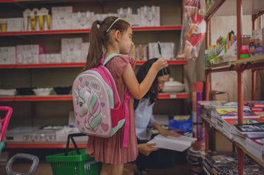 一个小孩和一个背包回到学校购物