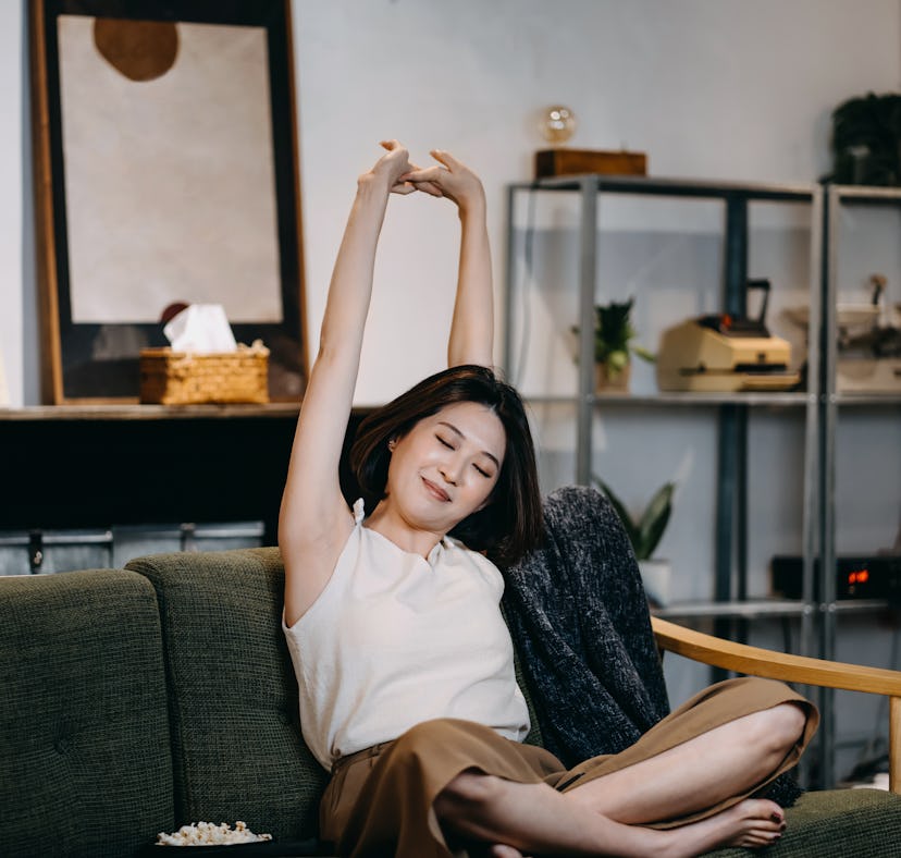 Young woman with her eyes closed stretching arms as one of the zodiac signs who will have the worst ...