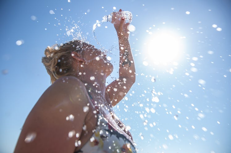 A young woman cools down with cold water during the summer heat.