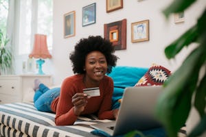 A woman with a credit card may be wondering what are the things to buy with credit card to build cre...