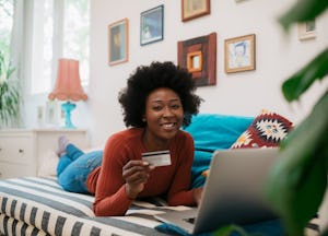 A woman with a credit card may be wondering what are the things to buy with credit card to build cre...