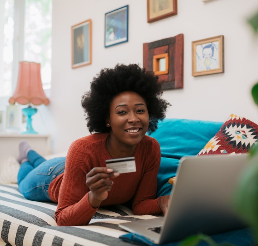 A woman with a credit card may be wondering what are the things to buy with credit card to build cre...