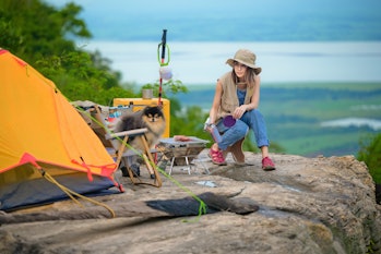 Woman traveler nomadic people enjoy the meal BBQ dinning on the camping on the cliff rock of view po...