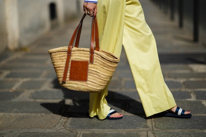 PARIS, FRANCE - MAY 10: Gabriella Berdugo wears yellow wide legs pants, a beige wickers and brown sh...