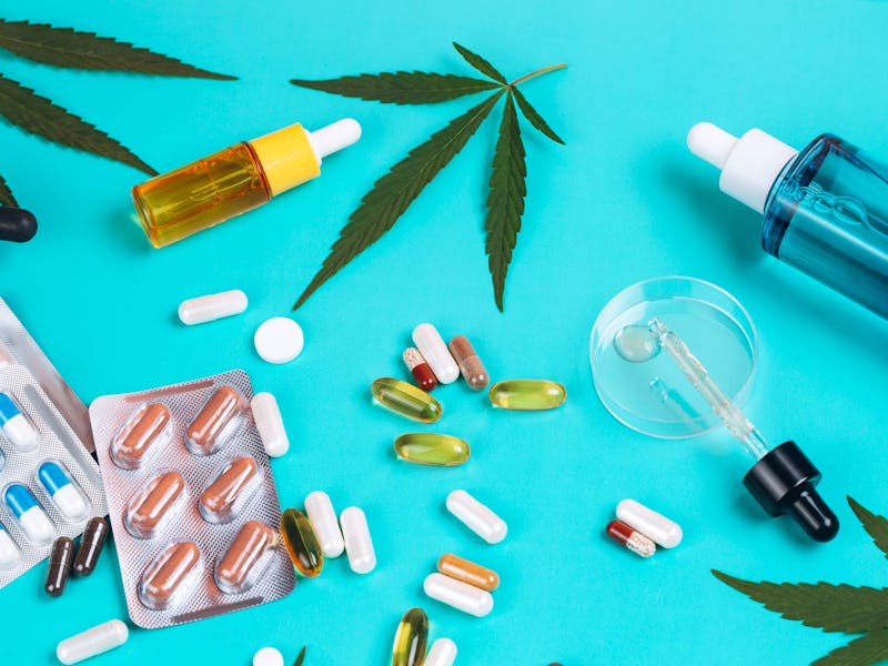 Set of products made of cannabis on turquoise background with cannabis leaves. Multicolored glass bo...